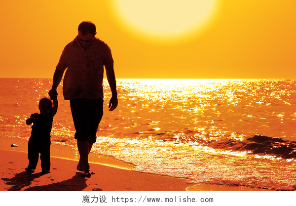 日落时分孩子与他的父亲在海边散步孩子与他的父亲在海上日落